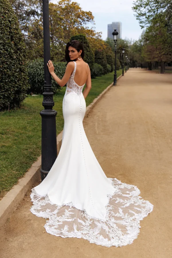 Dos nu boutonné et traîne en dentelle d'une robe de mariée sirène en crêpe