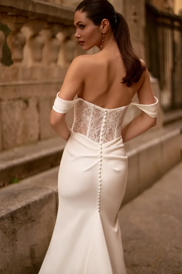 Dos corseté en dentelle et rangée de boutons d'une robe de mariée sirène en crêpe