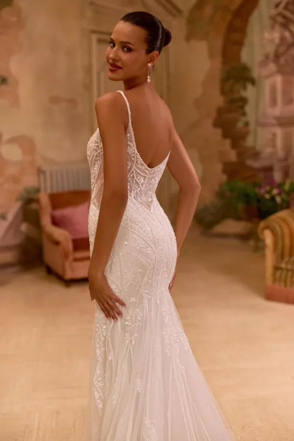 Dos nu à fines bretelles d'une robe de mariée sirène entièrement brodée