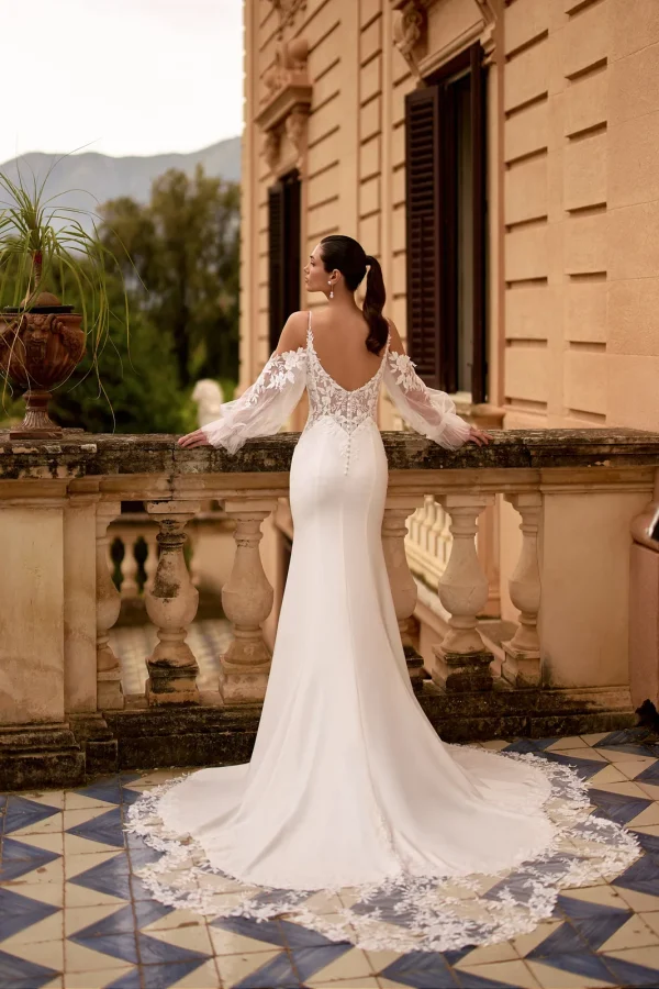 Dos nu et traîne en dentelle d'une robe de mariée sirène en crêpe à manches bouffantes