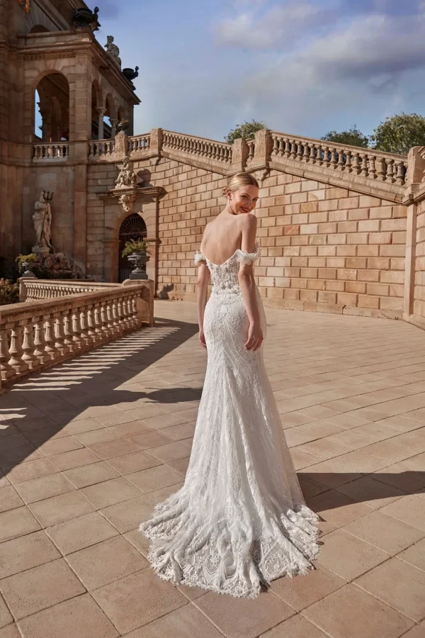 Dos nu et traîne en dentelle d'une robe de mariée sirène à col Bardot