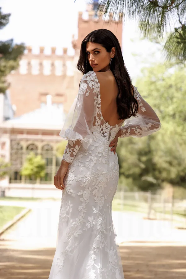 Dos nu arrondi et manches bouffantes transparentes d'une robe de mariée sirène