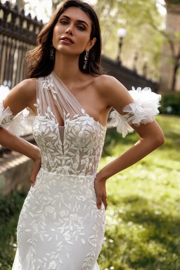 Bretelle asymétrique transparente et brassards en tulle d'une robe de mariée sirène