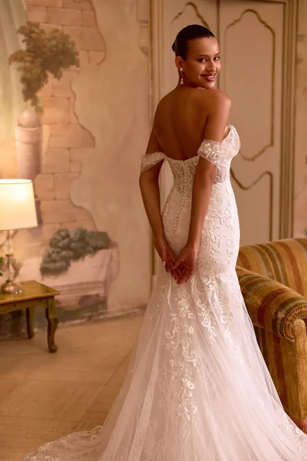 Dos corseté et traîne en dentelle d'une robe de mariée sirène à épaules dénudées