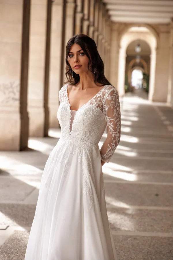 Manches transparentes et corsage brodé d'une robe de mariée trapèze en mousseline