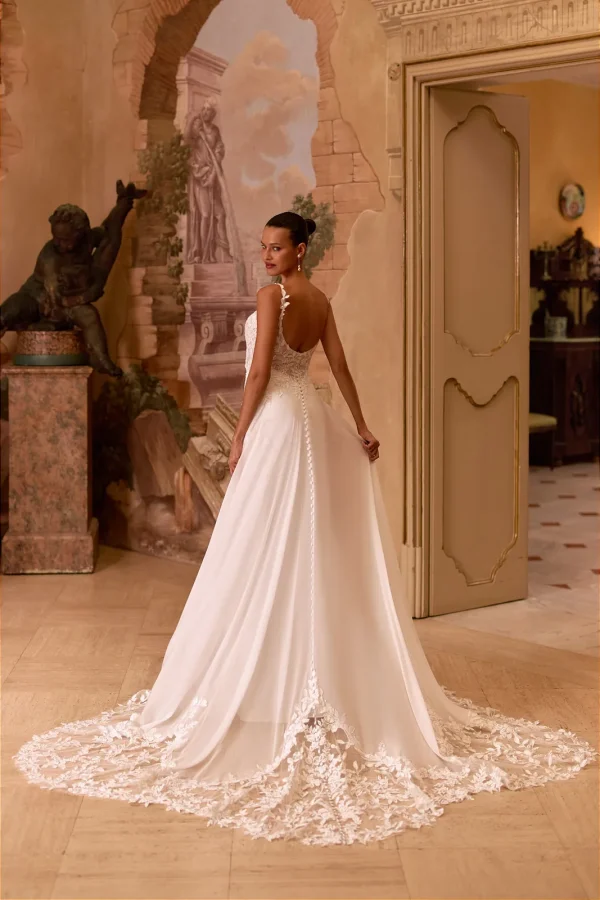 Traîne en dentelle et boutons d'une robe de mariée trapèze en mousseline