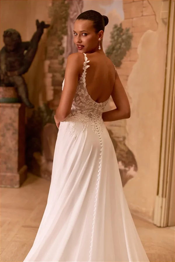Dos nu et rangée de boutons d'une robe de mariée trapèze en mousseline