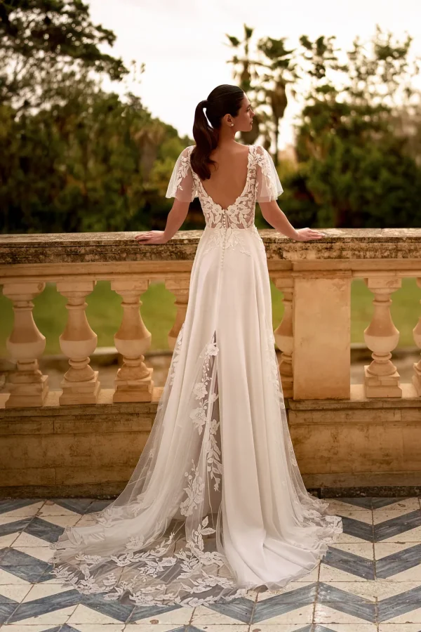 Dos nu en V et traîne en dentelle d'une robe de mariée trapèze en mousseline