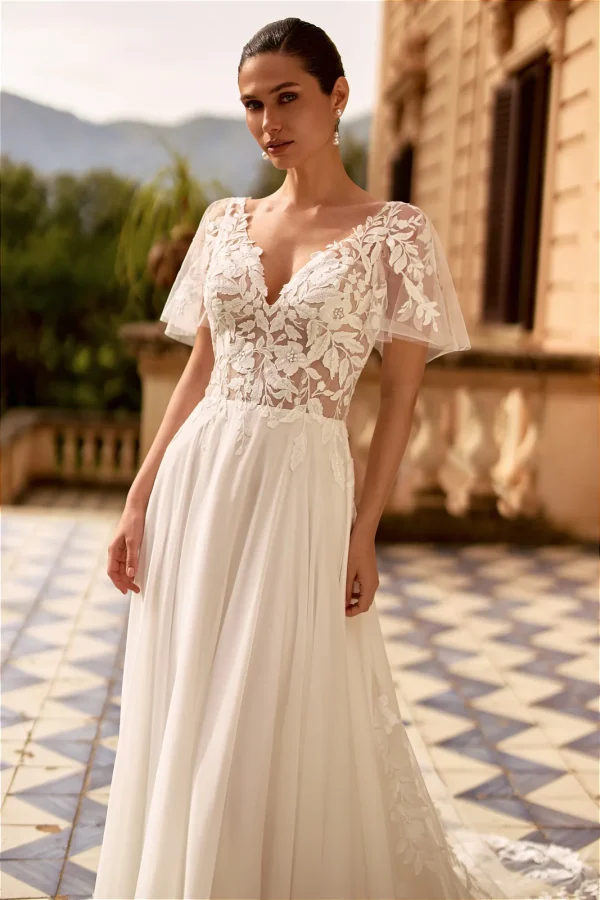Manches papillon et corsage en dentelle à col en V d'une robe de mariée trapèze
