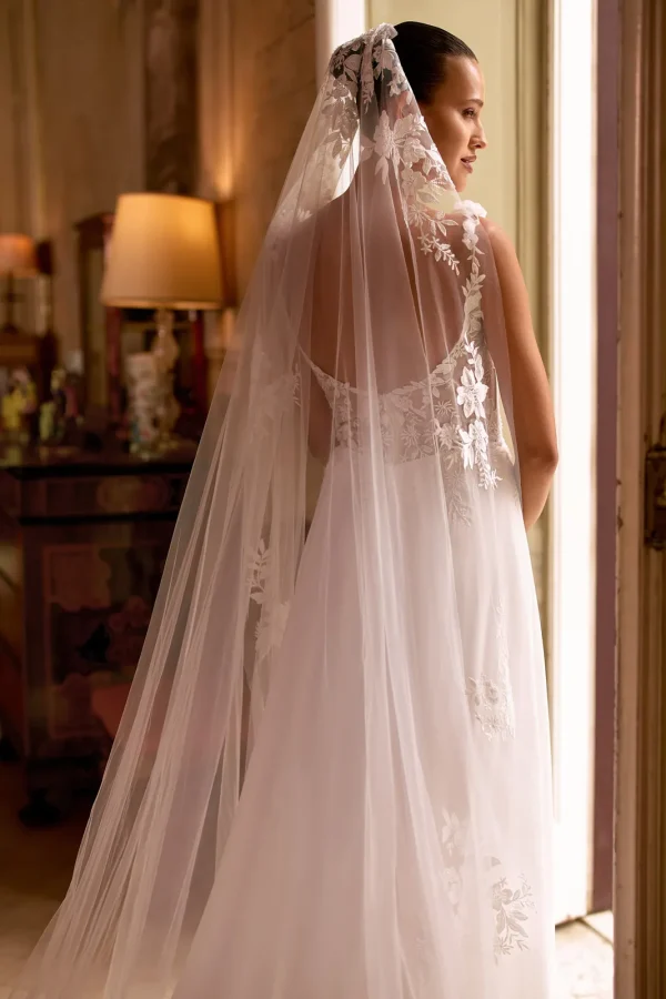 Voile 007 en tulle et dentelle porté sur le dos nu d'une robe de mariée trapèze