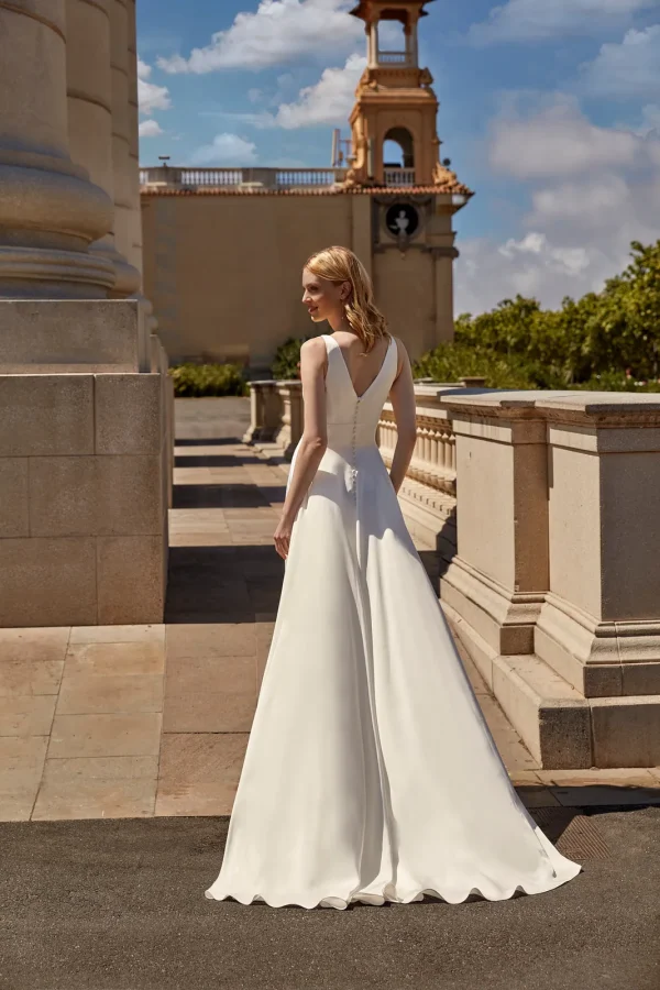 Dos en V boutonné d'une robe de mariée trapèze en satin
