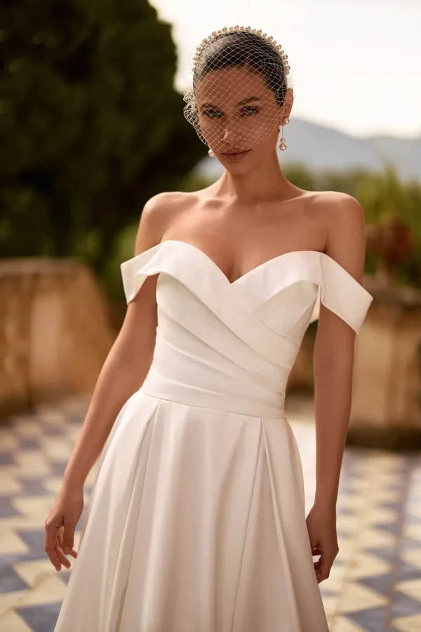 Col Bardot drapé et taille plissée d'une robe de mariée trapèze en satin