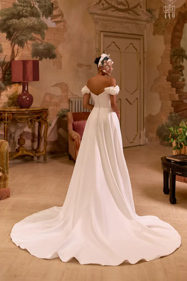 Dos en V boutonné et traîne d'une robe de mariée trapèze en satin