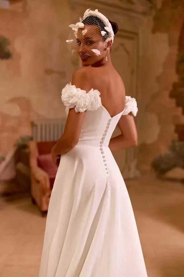 Dos en V et rangée de boutons d'une robe de mariée trapèze en satin à roses