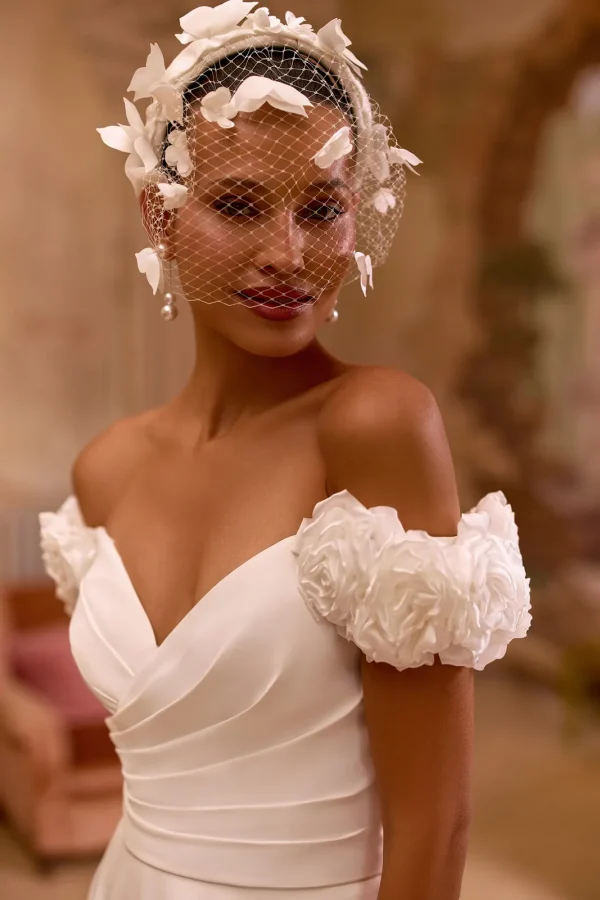 Roses en satin sur les épaules et décolleté cœur drapé d'une robe de mariée trapèze