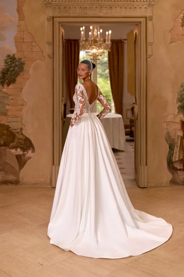 Dos nu en V et traîne d'une robe de mariée trapèze en satin à manches longues