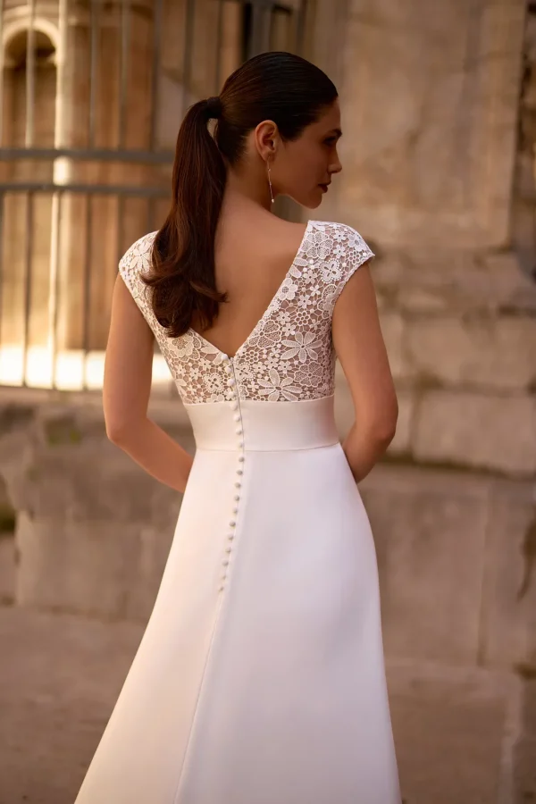 Dos en V en guipure et boutons d'une robe de mariée trapèze en satin