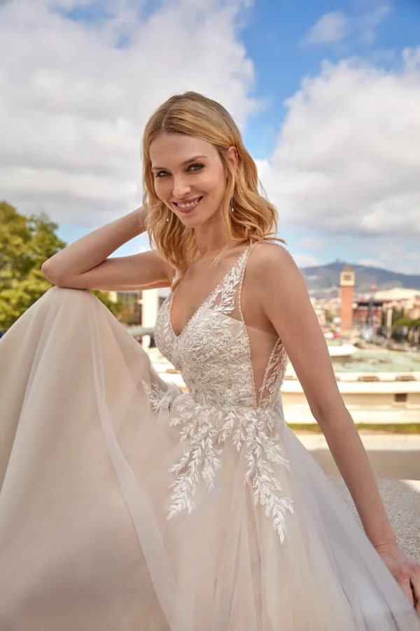 Corsage brodé de feuillage et flancs ouverts d'une robe de mariée trapèze nude