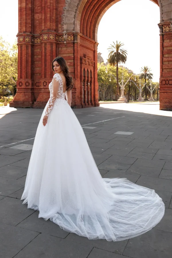 Dos en dentelle et traîne en tulle d'une robe de mariée trapèze à manches longues