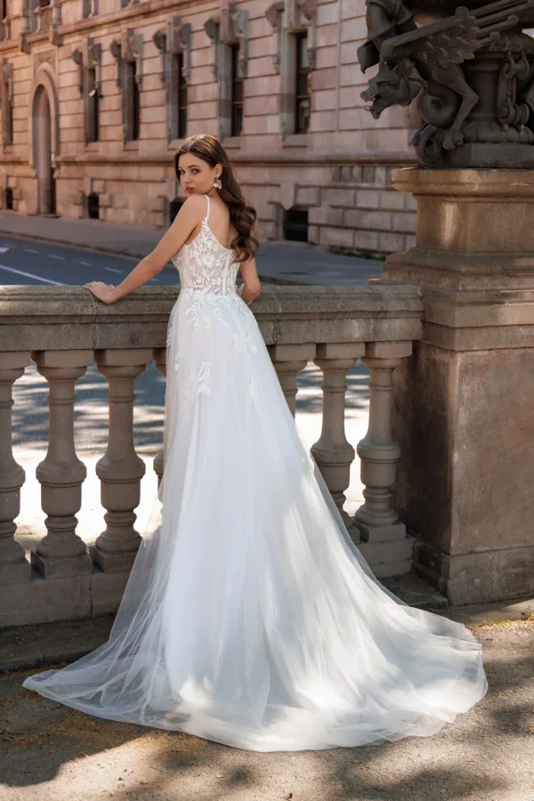 Dos nu et traîne en tulle d'une robe de mariée trapèze à fines bretelles