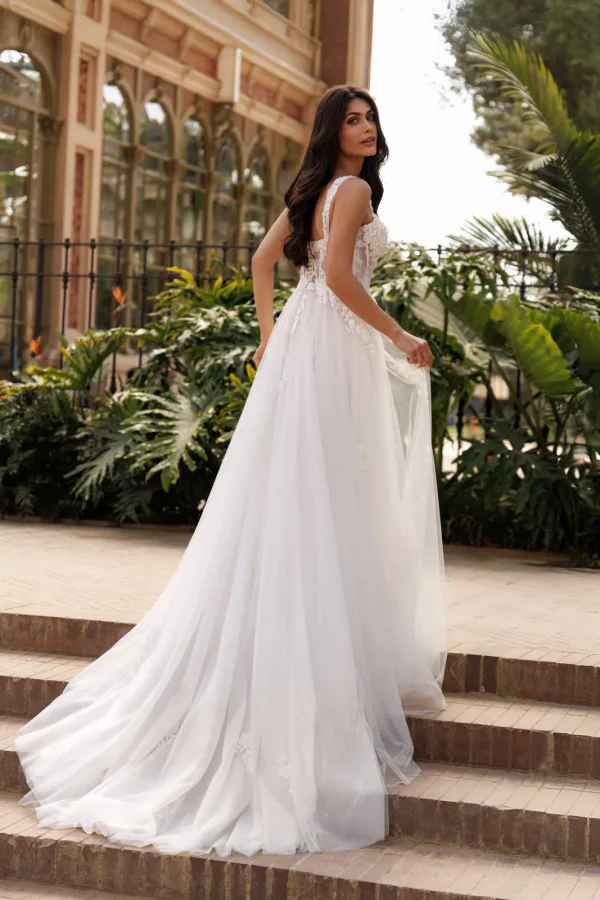 Dos et traîne en tulle d'une robe de mariée trapèze à corset brodé