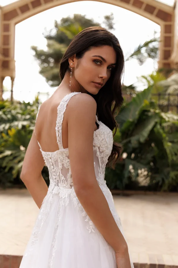 Dos corseté et larges bretelles en dentelle d'une robe de mariée trapèze