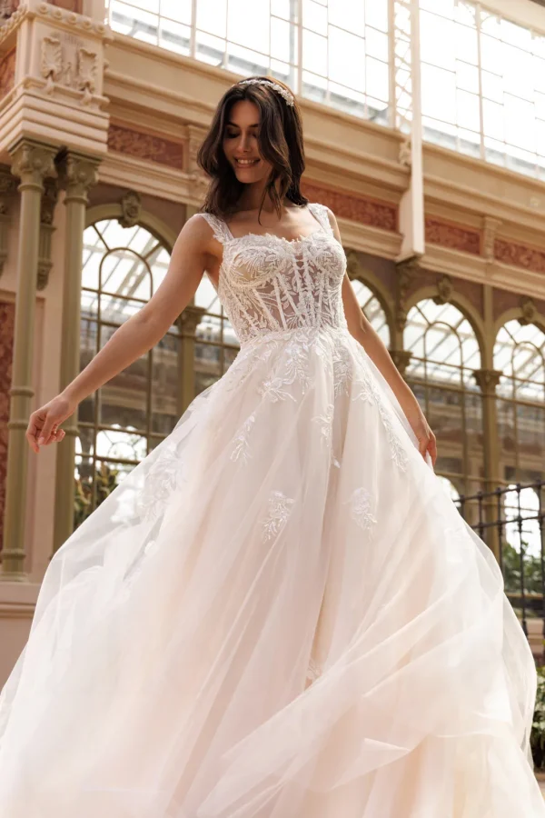 Corset transparent brodé et jupe en tulle d'une robe de mariée trapèze nude