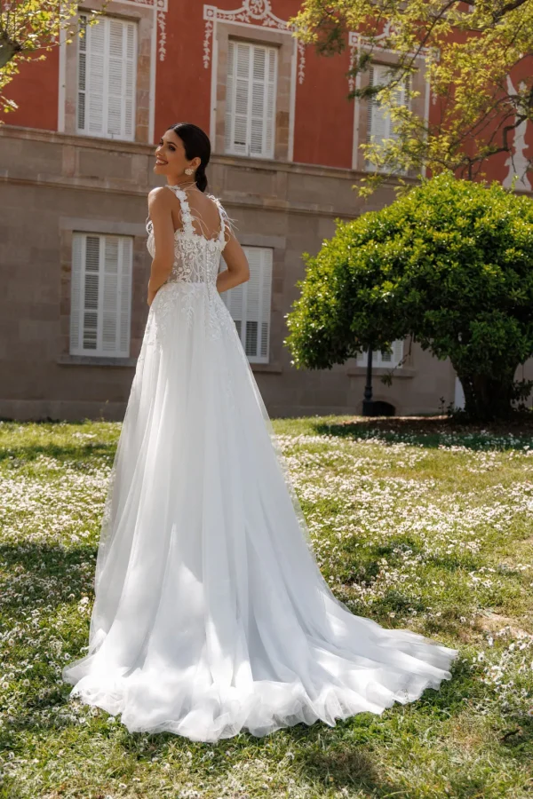 Dos et traîne en tulle d'une robe de mariée trapèze à bretelles fleuries