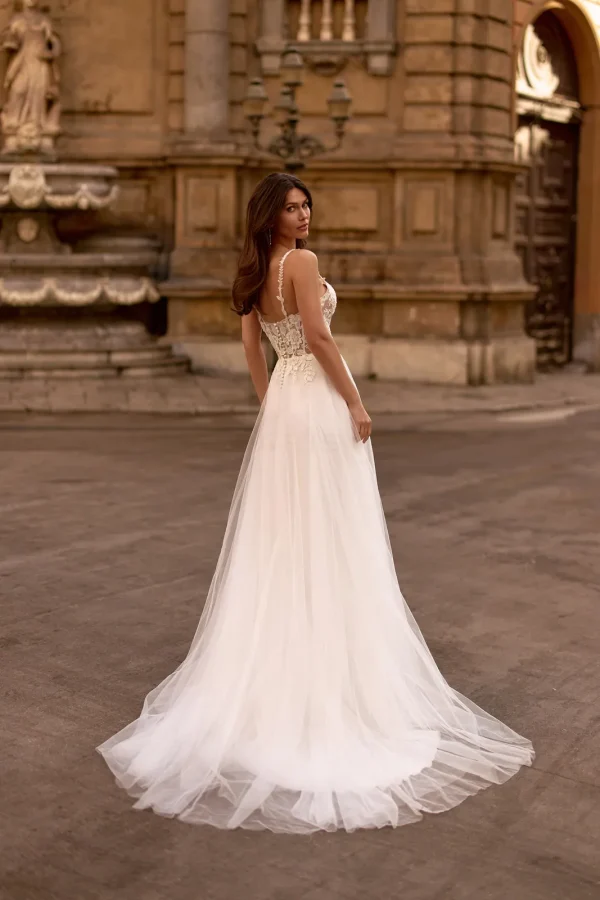 Dos et traîne en tulle d'une robe de mariée trapèze à fines bretelles