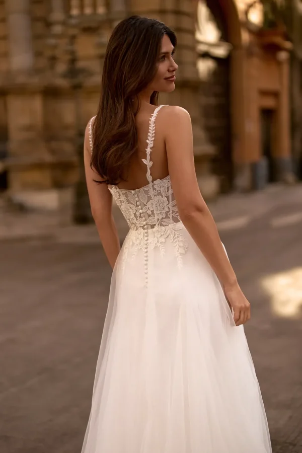 Dos boutonné et bretelles en dentelle d'une robe de mariée trapèze en tulle