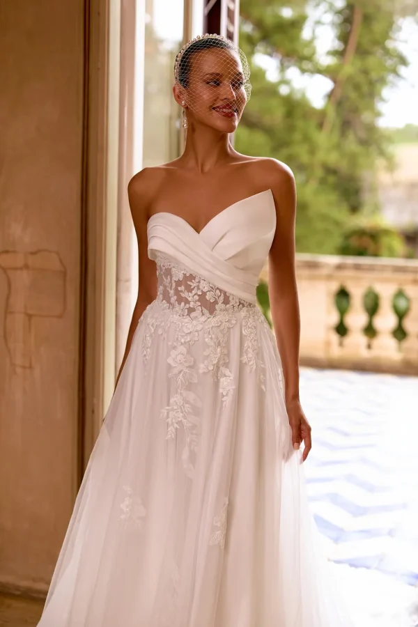 Bustier asymétrique drapé et taille transparente d'une robe de mariée trapèze en tulle