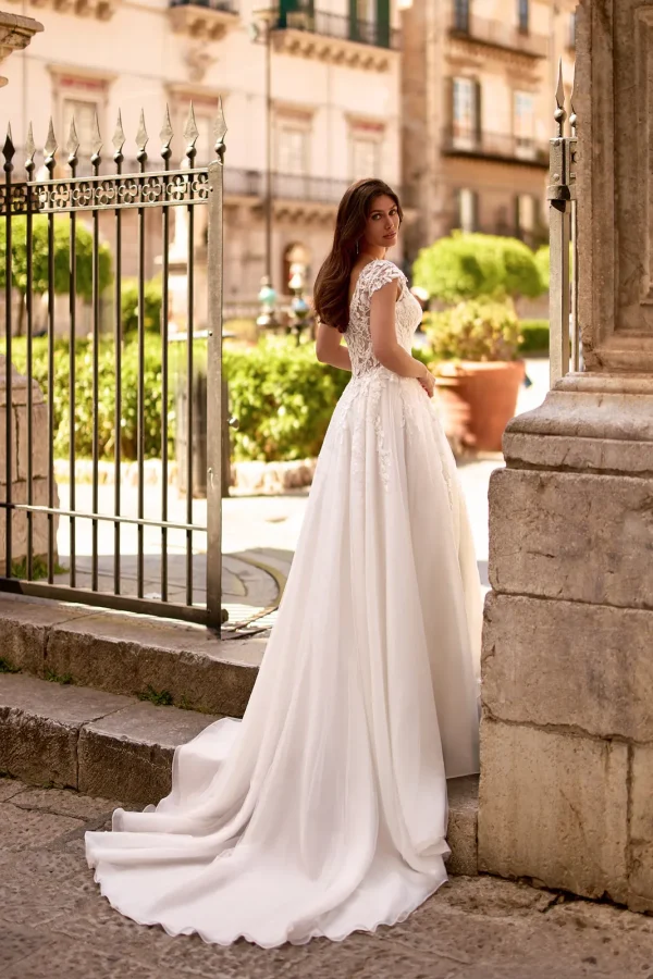 Dos en V et traîne en tulle d'une robe de mariée trapèze à mancherons