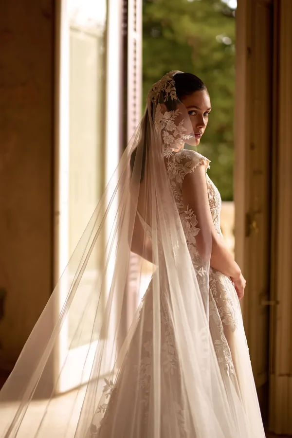 Voile 007 en tulle porté sur une robe de mariée trapèze nude à mancherons