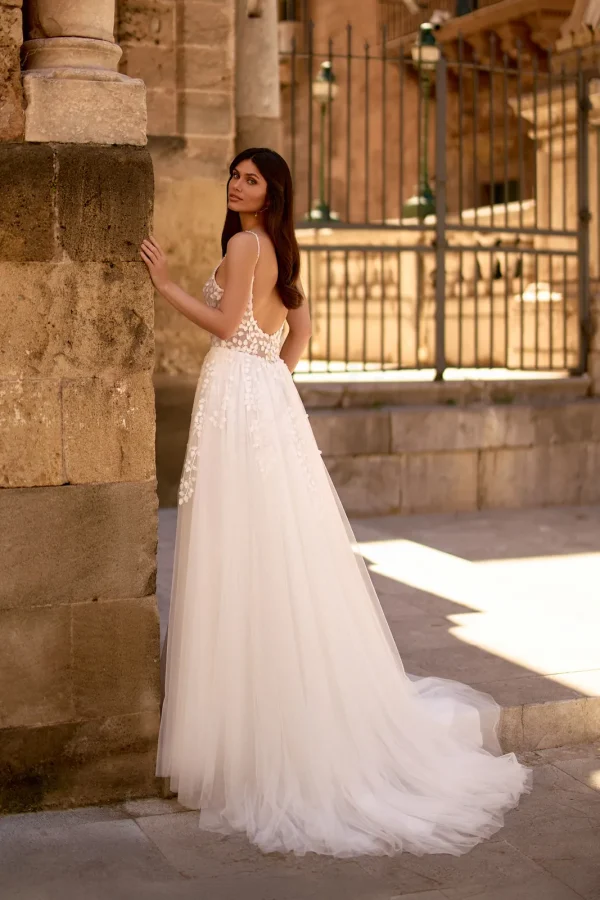 Dos nu et traîne d'une robe de mariée trapèze en tulle à pétales