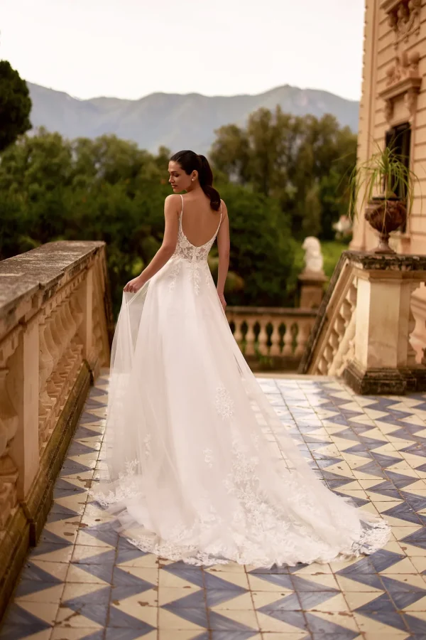 Dos nu et traîne en dentelle d'une robe de mariée trapèze à fines bretelles