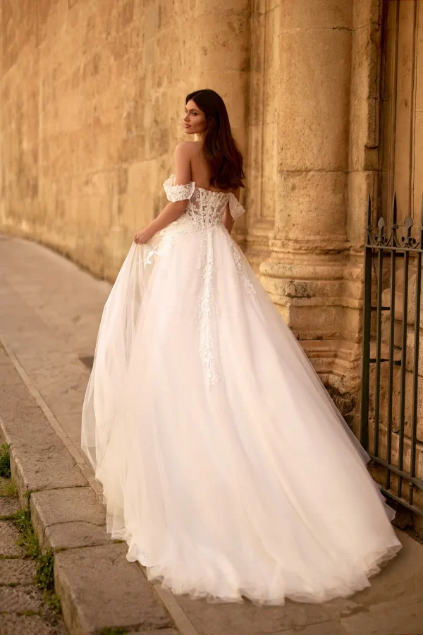 Dos et traîne en tulle d'une robe de mariée trapèze à épaules dénudées