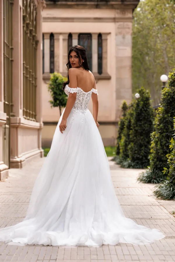 Dos corseté et longue traîne d'une robe de mariée trapèze en tulle à épaules dénudées